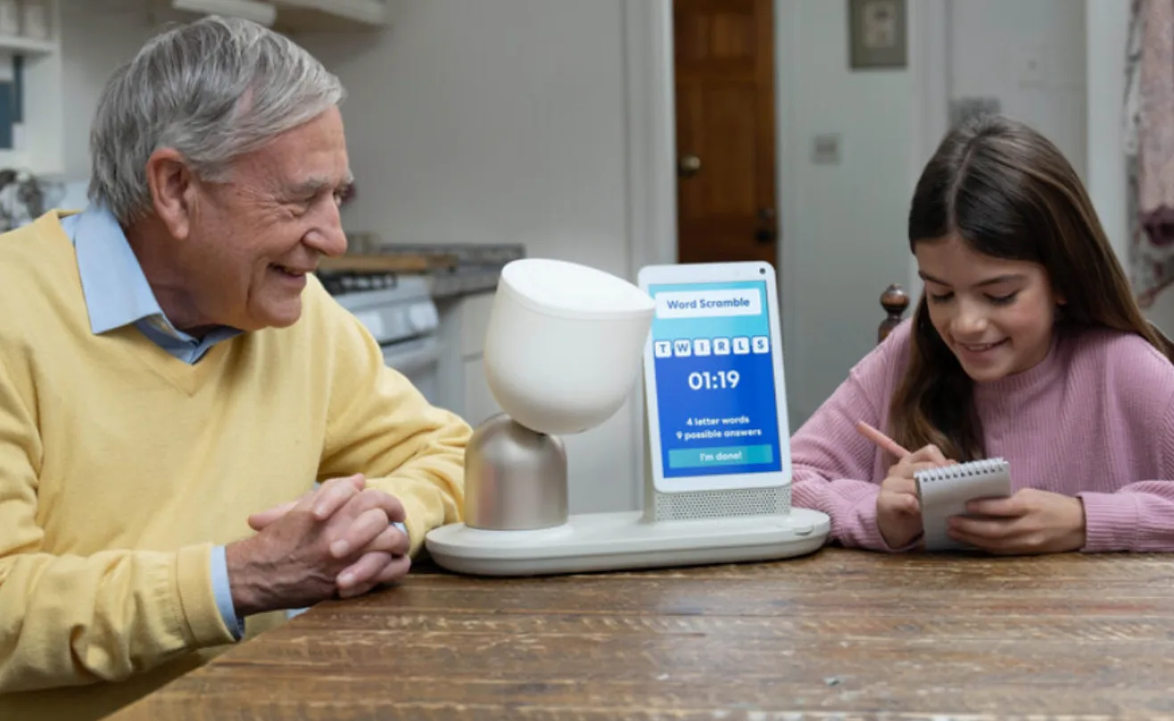 An older man and a child using ElliQ together