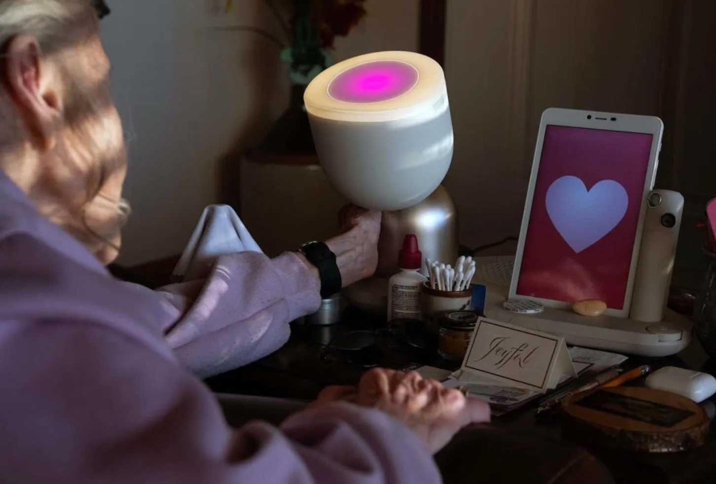 ElliQ on a bedside table beside its screen