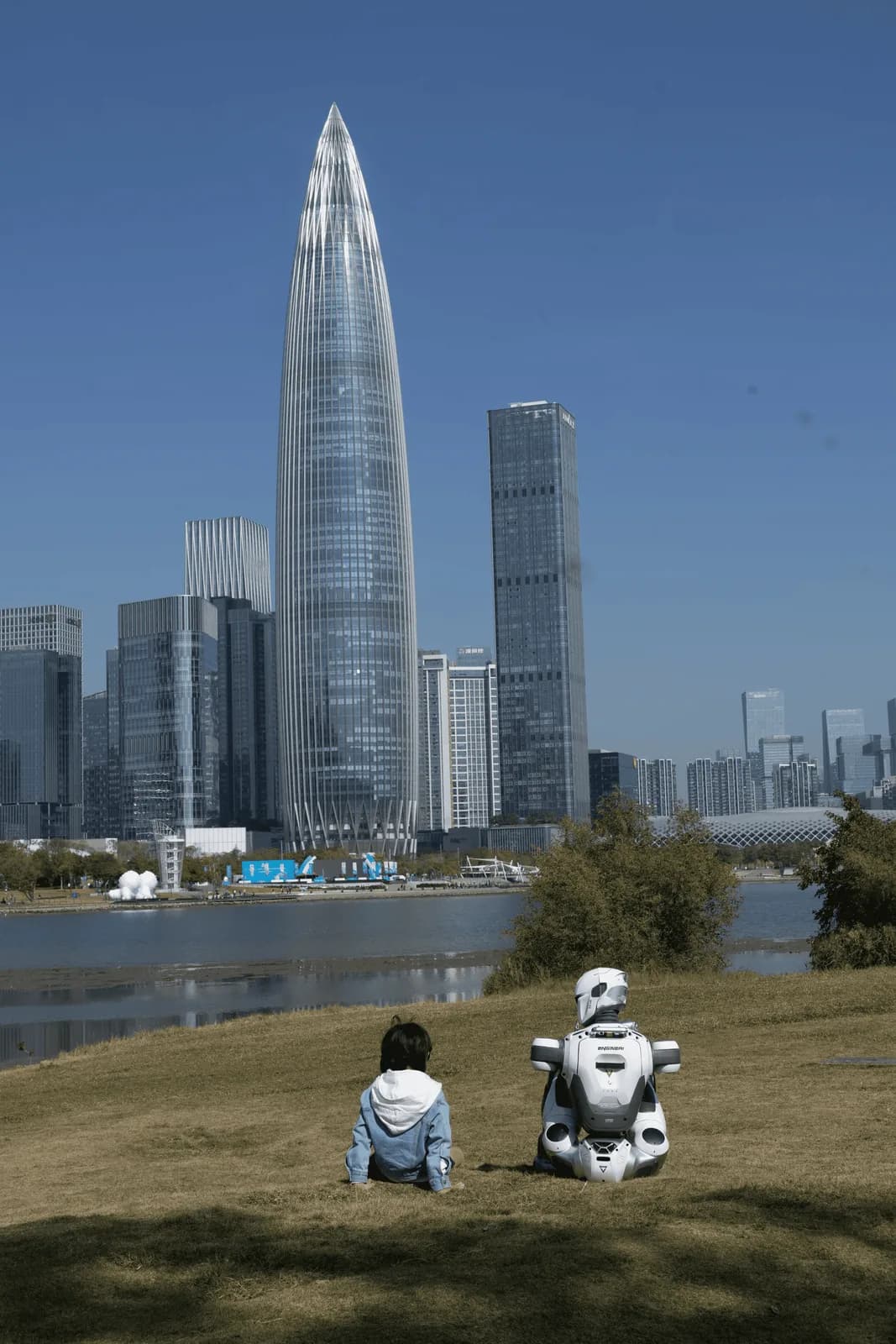 An EngineAI humanoid robot sitting with a child overlooking Shenzhen