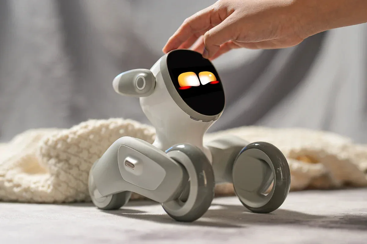 A hand reaching out to the Loona Petbot robot
