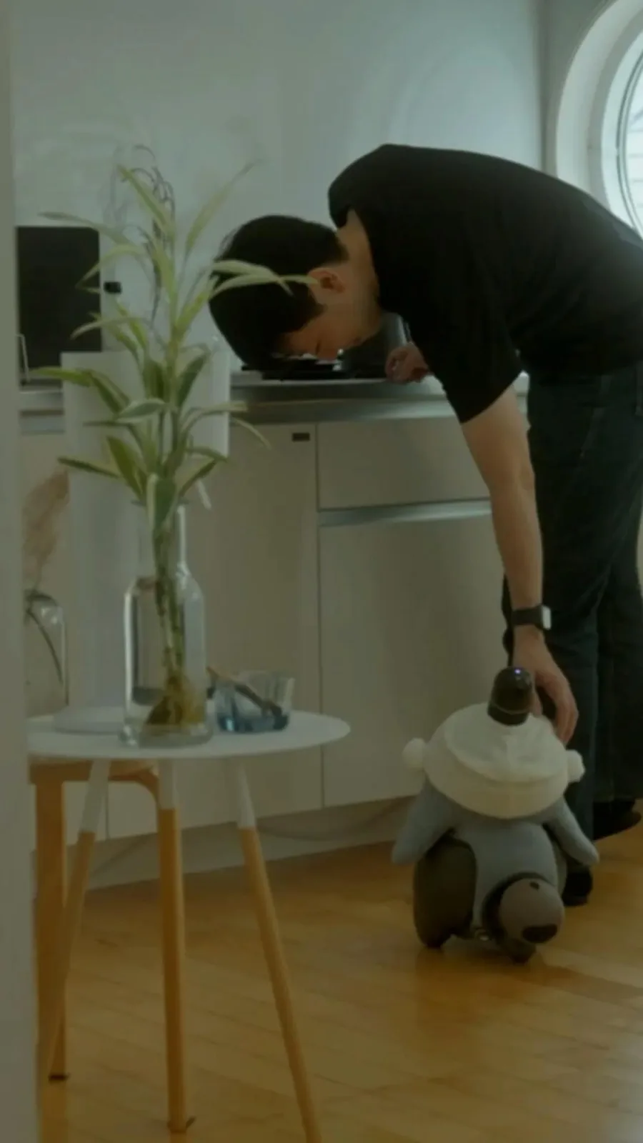 A LOVOT robot beside a person in a living room